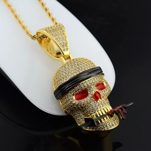 Makroaufnahme von Hip-Hop-Totenkopf-Anhänger mit weißen Steinen und Schwert auf Goldkette