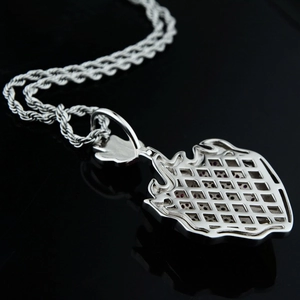 Macro detail of silver hip-hop pendant showing hollow mesh back and purple gemstones