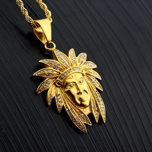 Détail macro du pendentif chef indien doré avec strass et chaîne maille torsadée