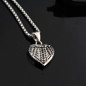 Vue détaillée du pendentif cœur ailé vintage en argent avec une chaîne maille vénitienne