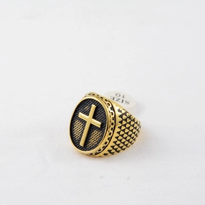 Detail of gold titanium ring with black honeycomb pattern and embossed cross