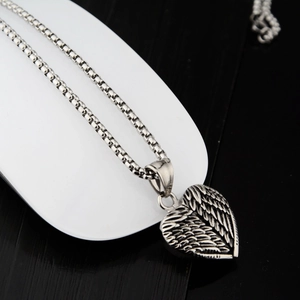 Collier avec pendentif coeur et détails d'ailes de plumes en acier inoxydable poli
