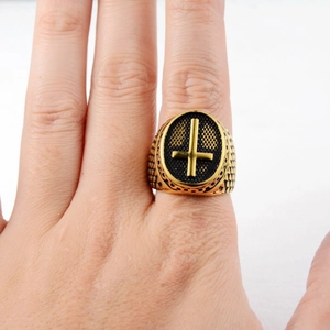Close-up of men's gold signet ring with black honeycomb and inverted cross motif