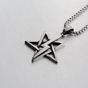 Macro shot of a punk lightning bolt and pentagram steel pendant on box chain