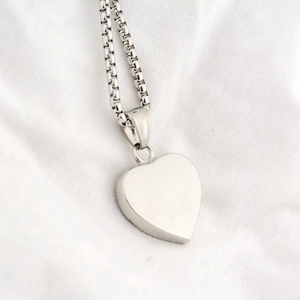 Vue détaillée d'un pendentif en forme de cœur poli sur une chaîne maille miroir