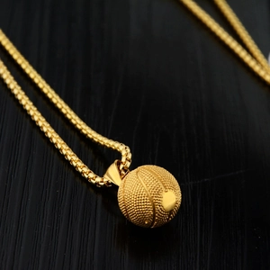Nahaufnahme eines 3D Basketball-Anhängers in Gold mit Box-Kette auf schwarzem Holzgrund