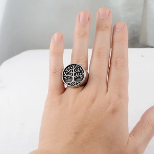 Detail of vintage Tree of Life ring in titanium steel worn on hand with silver black finish