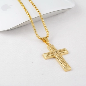 Three-dimensional golden cross pendant necklace with box chain on a clean white background