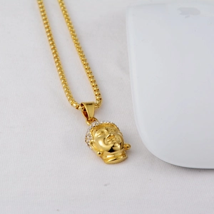 Macro detail of gold Buddha head pendant with sparkling rhinestones and bead chain necklace
