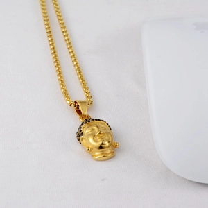 Macro shot of hip-hop Buddha pendant necklace with black rhinestones and golden box chain