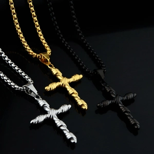 Trois pendentifs croix torsadés en or, argent et noir sur des chaînes vénitiennes
