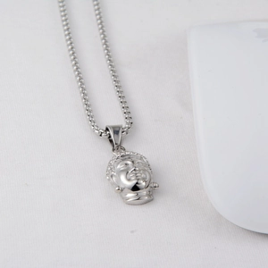 Detail of silver Buddha head pendant necklace with mirror finish on stainless steel