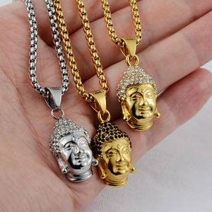 Detailed close-up of hip-hop Buddha pendants in gold and silver with sparkling crystals