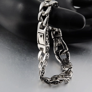 Detailed close-up of retro silver stainless steel Cuban link bracelet with tribal engravings