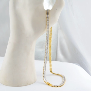 Detail view of a gold-plated tennis necklace with rectangular white cubic zirconia stones
