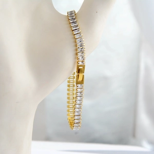 Macro shot of gold-plated tennis bracelet with baguette-cut stones on a wrist