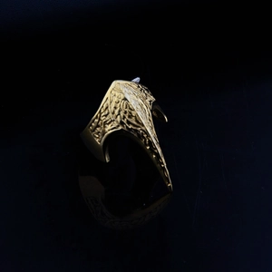 Detail view of gold vintage engraved band ring for men with floral pattern on black surface