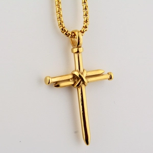 Detailed view of golden nail cross pendant with rugged wire wrap on a box chain