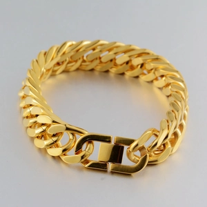 Close-up of golden stainless steel Cuban link bracelet with a heavy-duty mechanical clasp