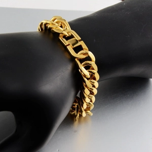 Detail of gold-plated titanium steel Cuban chain bracelet on a black hand model display