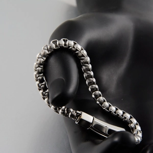 Vue détaillée du bracelet gourmette en acier argenté avec fermoir carré sur mannequin noir