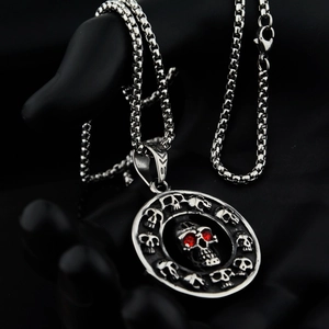 Macro shot of gothic skull pendant with red zircon eyes and vintage silver box chain
