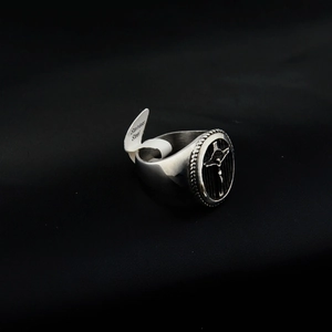 Gros plan sur bague vintage en acier inoxydable avec relief croix noire et bord torsadé
