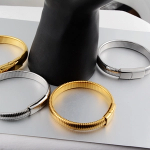 Detail view of gold and silver ribbed titanium steel bracelets with magnetic clasps