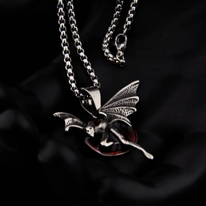 Macro shot of gothic titanium steel bat pendant with a deep red resin inlay and chain