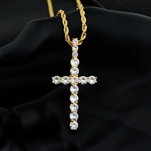 Nahaufnahme des Hip-Hop Goldkreuz-Anhängers mit Zirkonia auf schwarzem Handdisplay