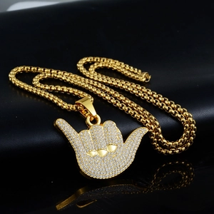 Dettaglio del ciondolo hip hop in oro con diamanti pavé e collana a catena quadrata