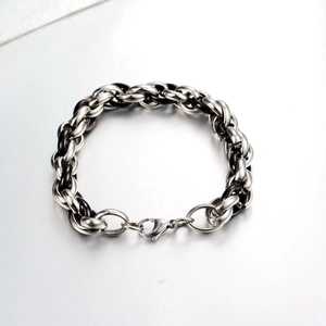 Detail eines klobigen Edelstahl-Gliederkettenarmbands mit schwarzen Gliedern und Karabiner