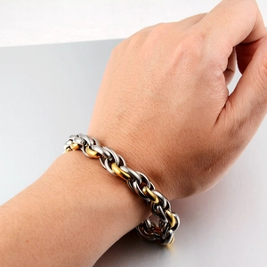 Hip-Hop Gliederkette aus Titanstahl in Gold und Silber am Handgelenk eines Mannes
