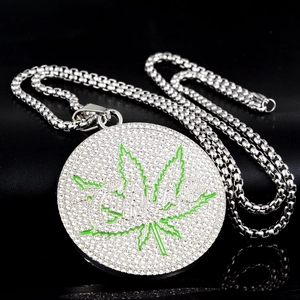 Vue macro d'un pendentif hip hop avec strass blancs et motif de feuille verte
