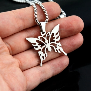 Close-up of a silver butterfly pendant with detailed hollow wings on a round box chain