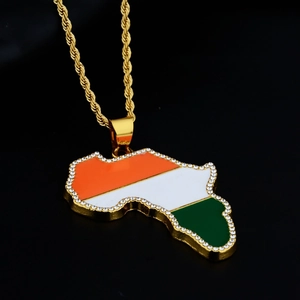Macro detail of iced-out Africa map pendant with tricolor enamel on a gold rope chain