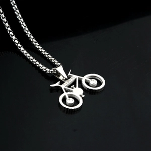 Vue macro d'un pendentif vélo en argent avec strass sur une chaîne de type boîte