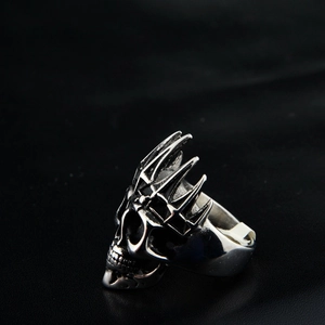 Macro shot of vintage silver skull ring with gothic crown detail on black background
