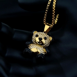 Macro shot of gold-plated panda pendant with black and white rhinestones and box chain