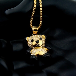 Macro view of gold panda pendant necklace with black and white rhinestones on silk