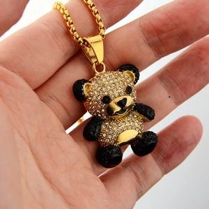 Macro view of gold panda pendant with clear rhinestones and box chain details