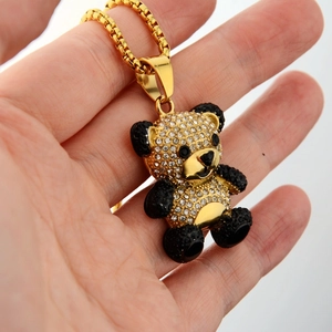 Detailed macro shot of a golden teddy bear pendant with sparkling crystal rhinestones