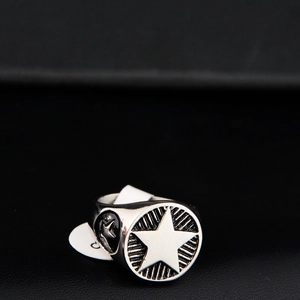 Détail macro d'une bague rétro en acier inoxydable avec étoile gravée et lignes radiales