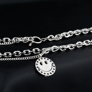 Detail of silver dual-layer necklace with smiley face star pendant and OT toggle closure