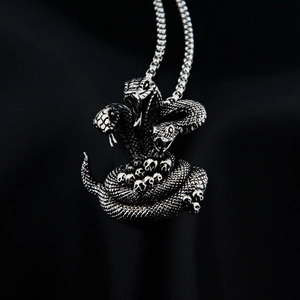 Macro d'un pendentif gothique de serpent et crâne en finition argentée antique