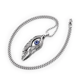Macro detail of retro steel feather pendant with blue evil eye on square box chain