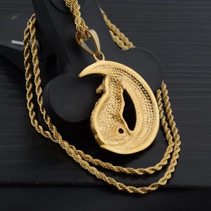 Collana con ciondolo lupo vichingo dorato con catena a corda su sfondo in legno scuro