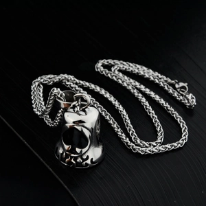 Detailed macro view of the silver ace of spades bell pendant with flame hollow carving