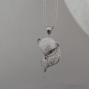 Vue macro du collier pendentif renard argenté avec strass brillants et yeux noirs