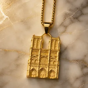 Macro view of gold Notre Dame pendant showing intricate Gothic architectural details